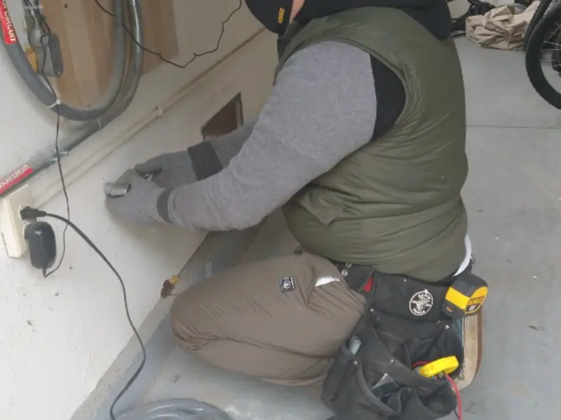 Electrician performing outlet wiring in a Fairmount garage